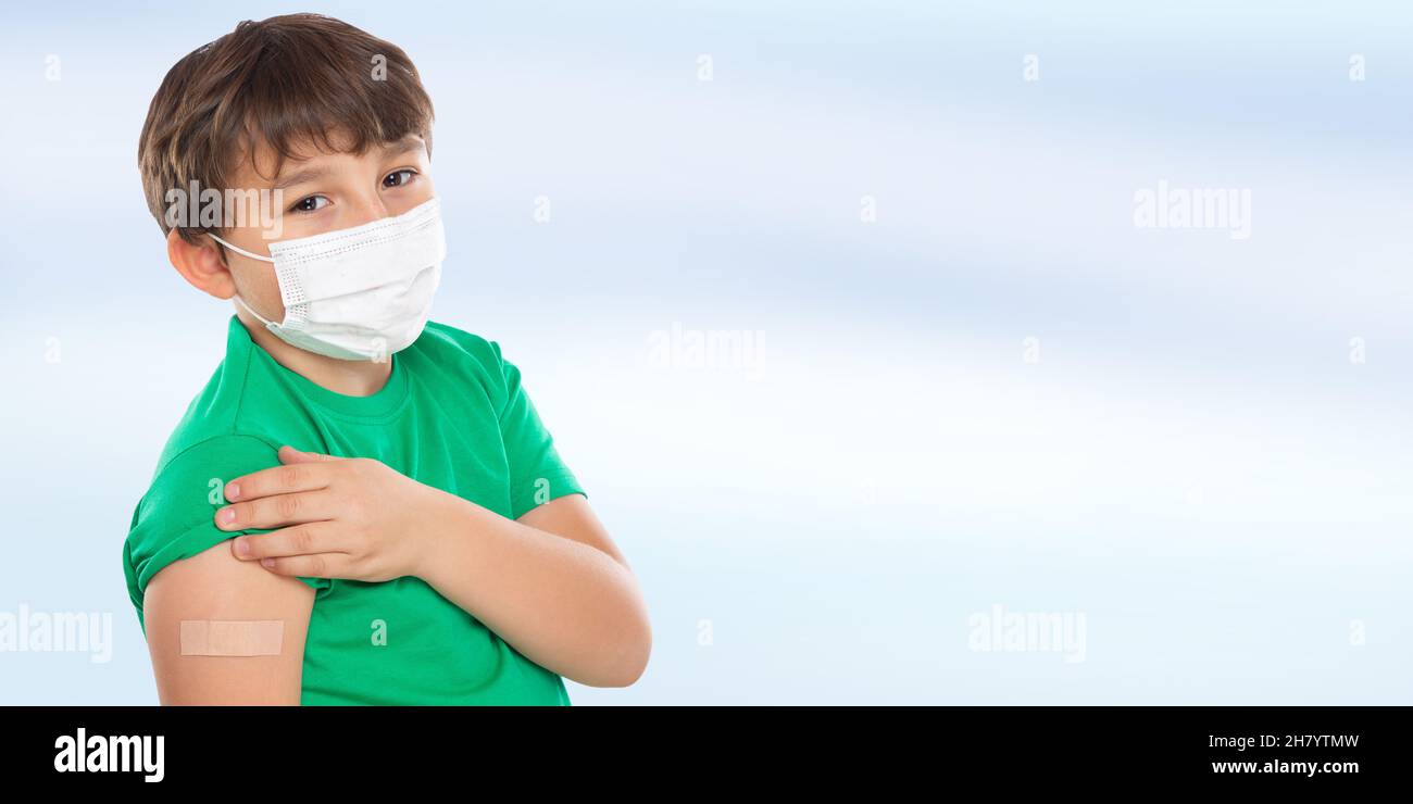 Child kid with plaster after Coronavirus vaccination wearing face mask against Corona Virus COVID-19 Covid copyspace copy space latin Stock Photo