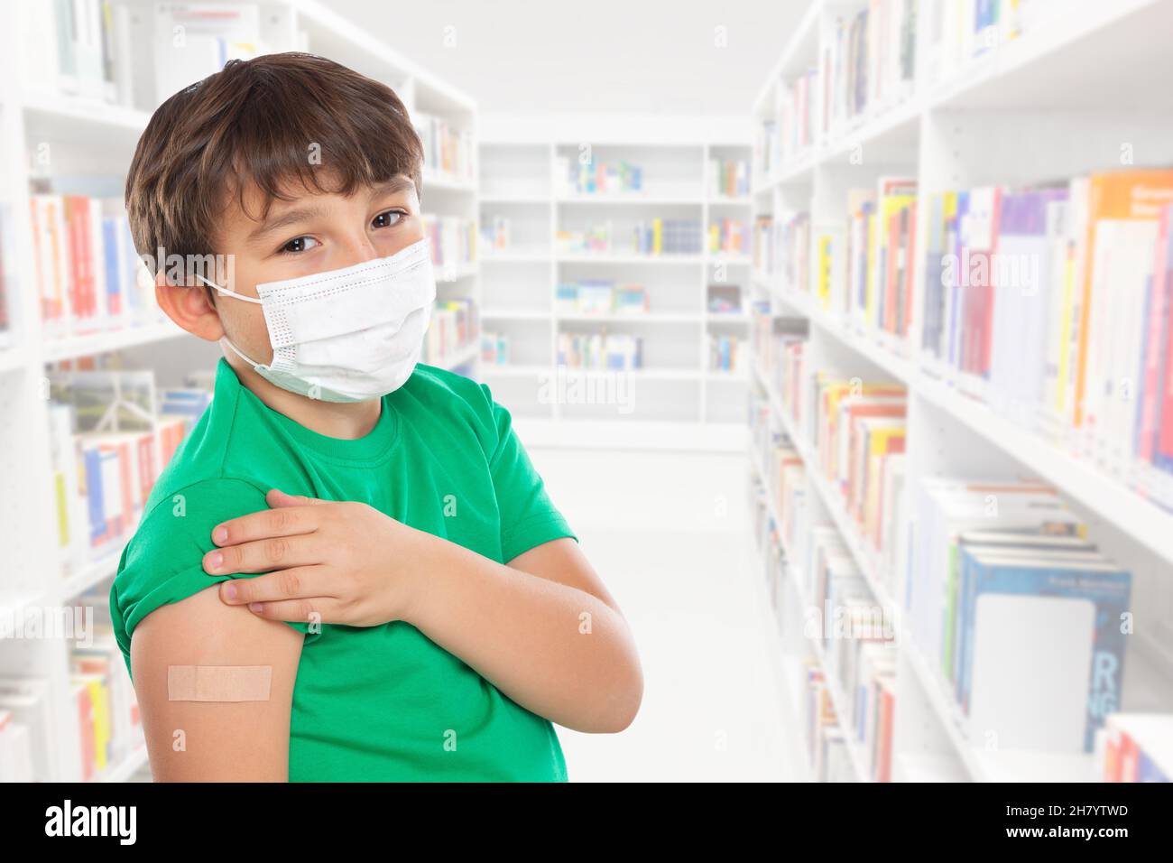 Child kid with plaster after Coronavirus vaccination wearing face mask at school against Corona Virus COVID-19 Covid copyspace copy space latin Stock Photo
