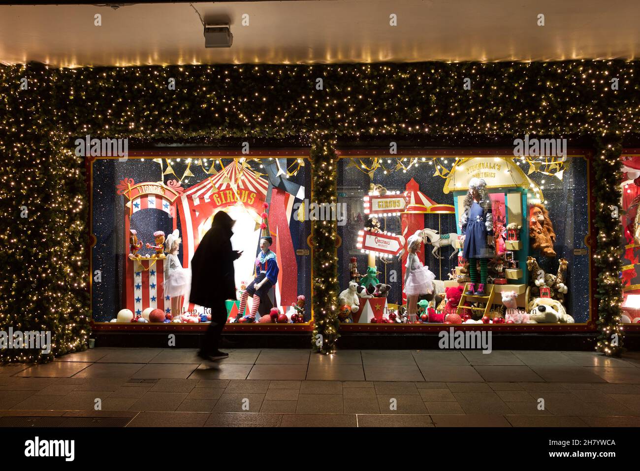 Dublin, Ireland - November 24, 2021: a passerby admires the circus themed Christmas window display at Arnotts Department Store on Henry Street. Stock Photo