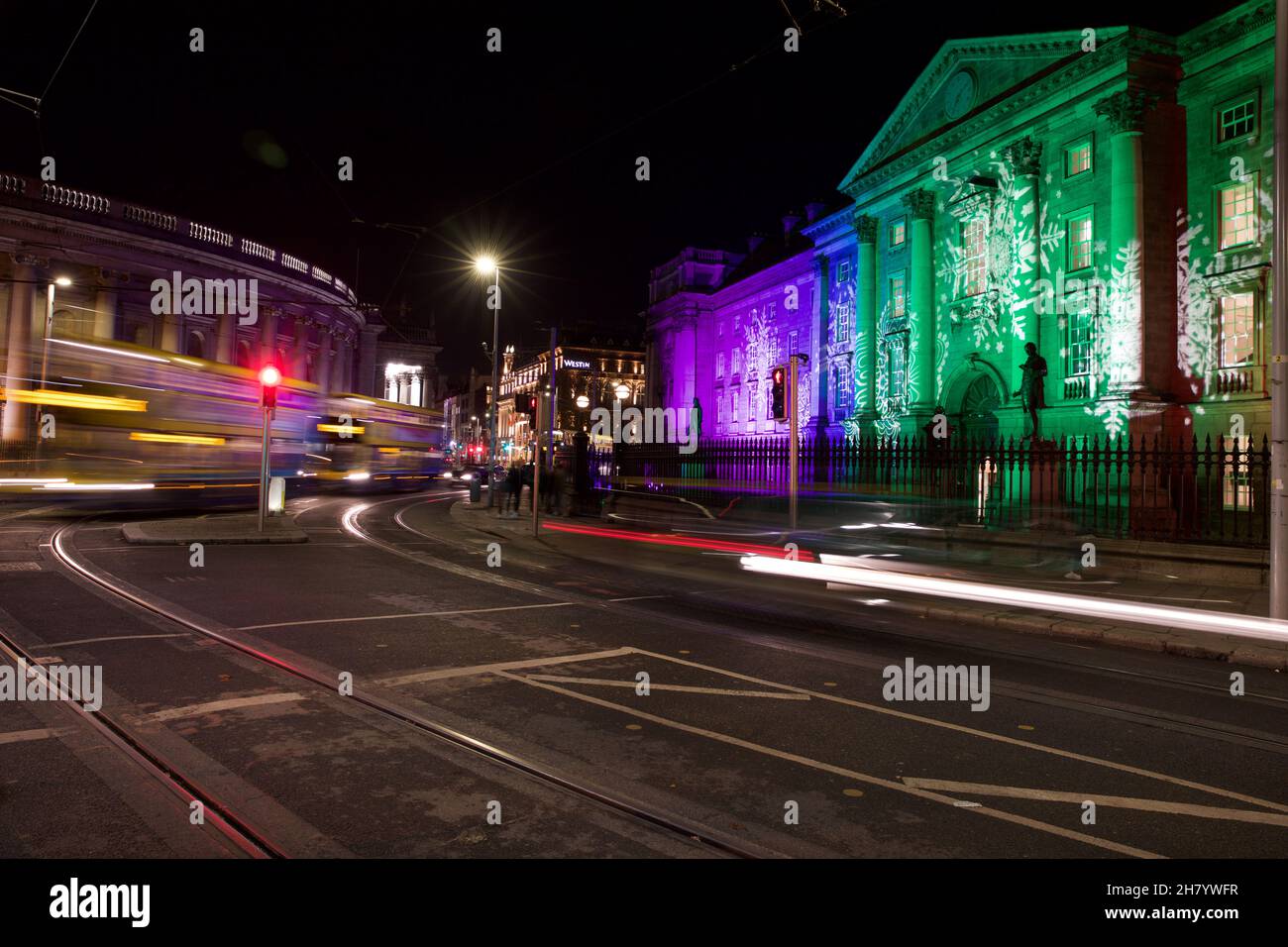 Dublin, Ireland - November 24, 2021: traffic light trails at College Green. Trinity College Dublin can be seen on the right, illuminated with a festiv Stock Photo