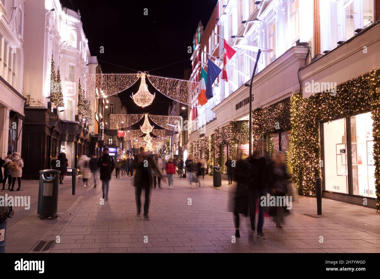 Dublin, Ireland - November 24, 2021: shoppers walk beneath the recently illuminated Christmas lights on Henry Street, the shopping thoroughfare on the Stock Photo