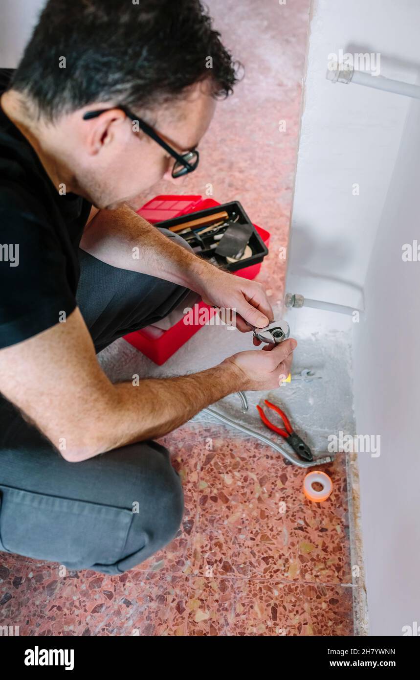 Plumber adjusting spanner to install heating Stock Photo