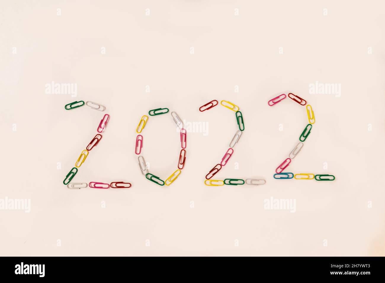 Number 2022 is laid out of multicolored paper clips on a white background.  Stock Photo