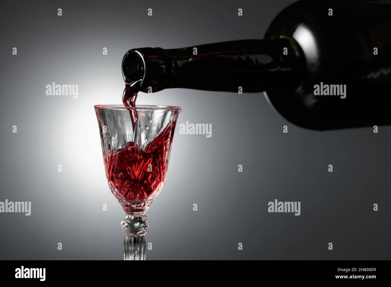 Dessert wine or liqueur is poured into a glass from an ancient bottle. Copy space. Stock Photo