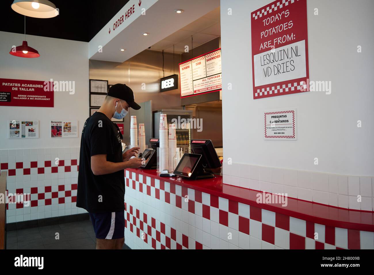 Barcelona, Spain 07/17/2020 A guy wearing a mandatory face mask buys fast food at Five Guys
