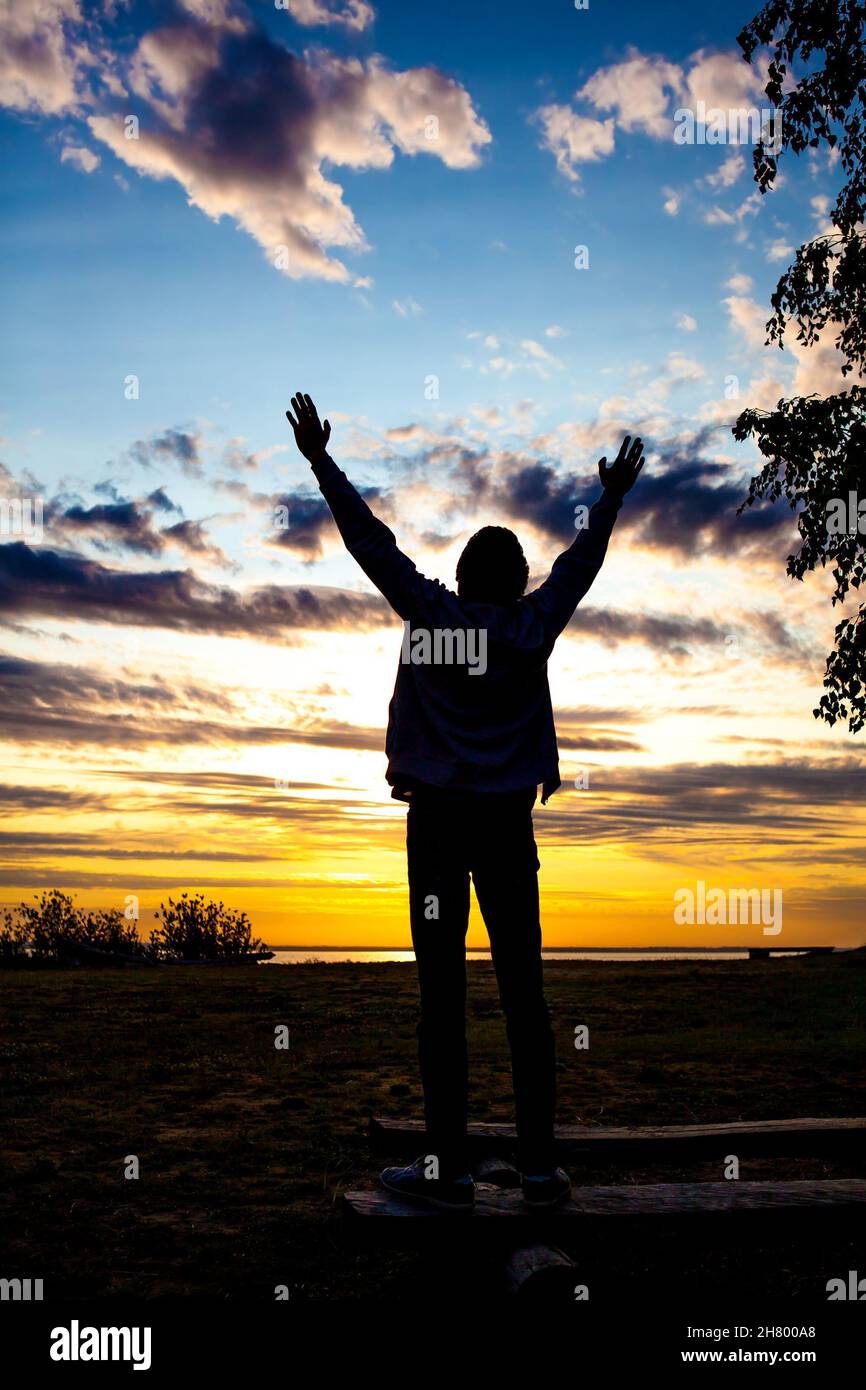Happy Man Silhouette with Hands Up on the Sunset Background Stock Photo ...