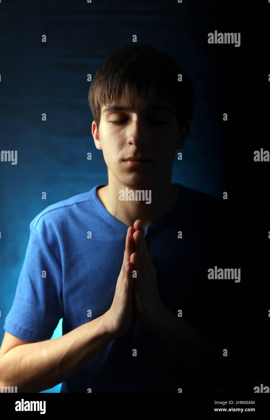 Young Man Praying in the Dark Room Stock Photo - Alamy