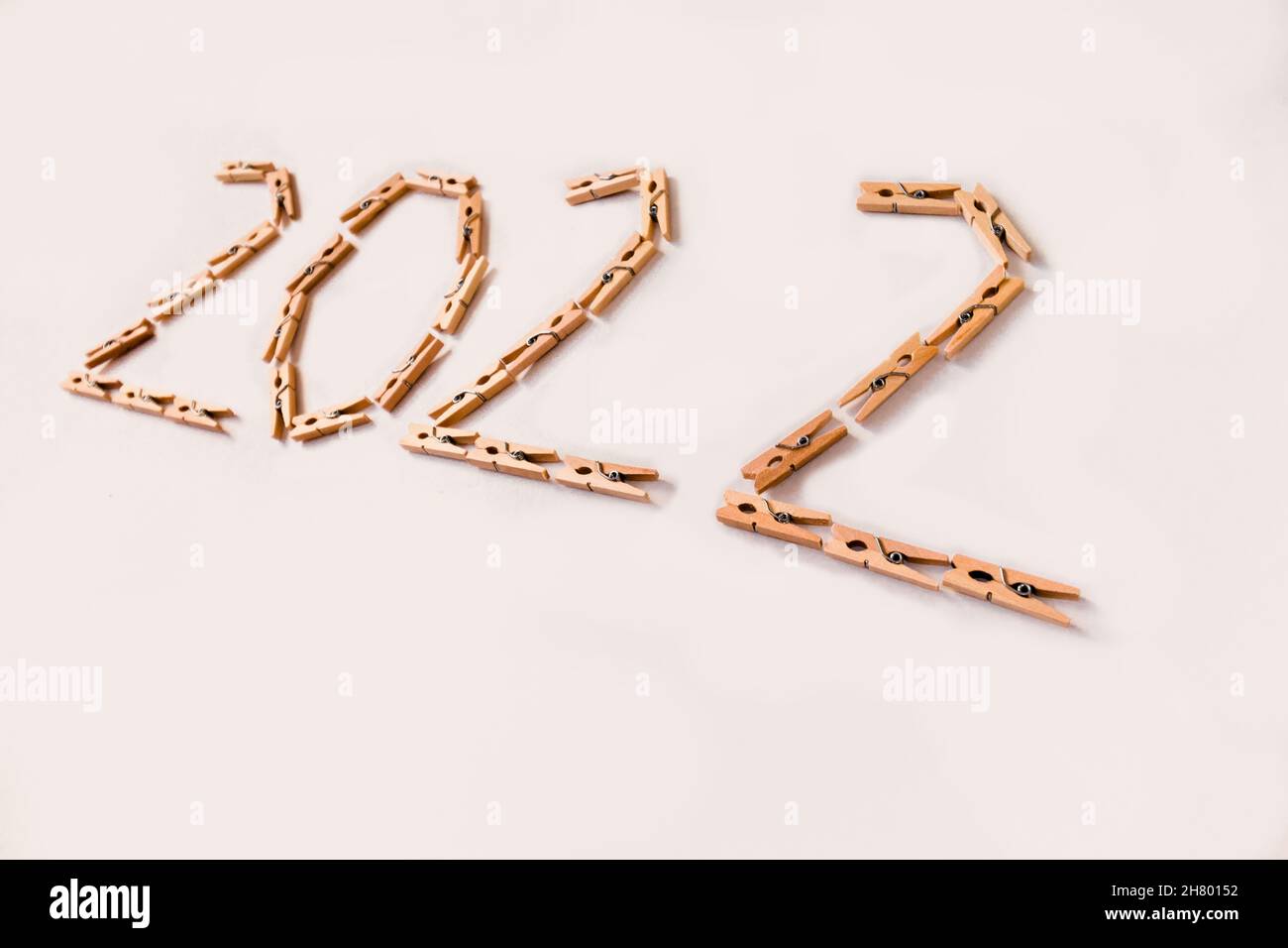 Number 2022 is made of small wooden clothespins on a white background. Stock Photo