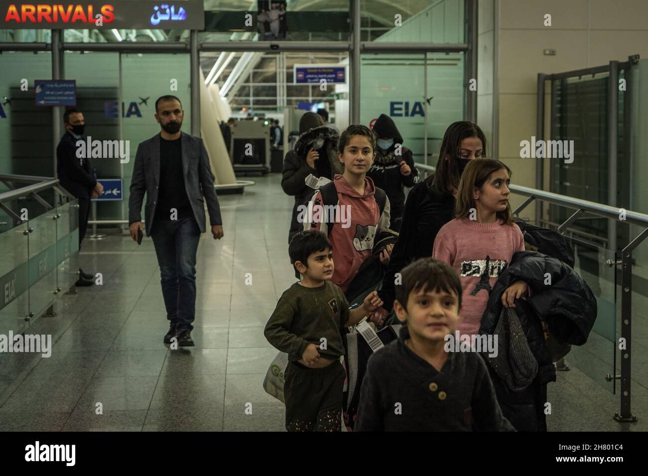 Erbil, Iraq. 26th Nov, 2021. Iraqi migrants, who were stranded for weeks along the Polish-Belarusian borders, walk through the arrivals terminal at Erbil International Airport, after arriving on board a repatriation flight sent by the Iraqi government. Credit: Ismael Adnan/dpa/Alamy Live News Stock Photo