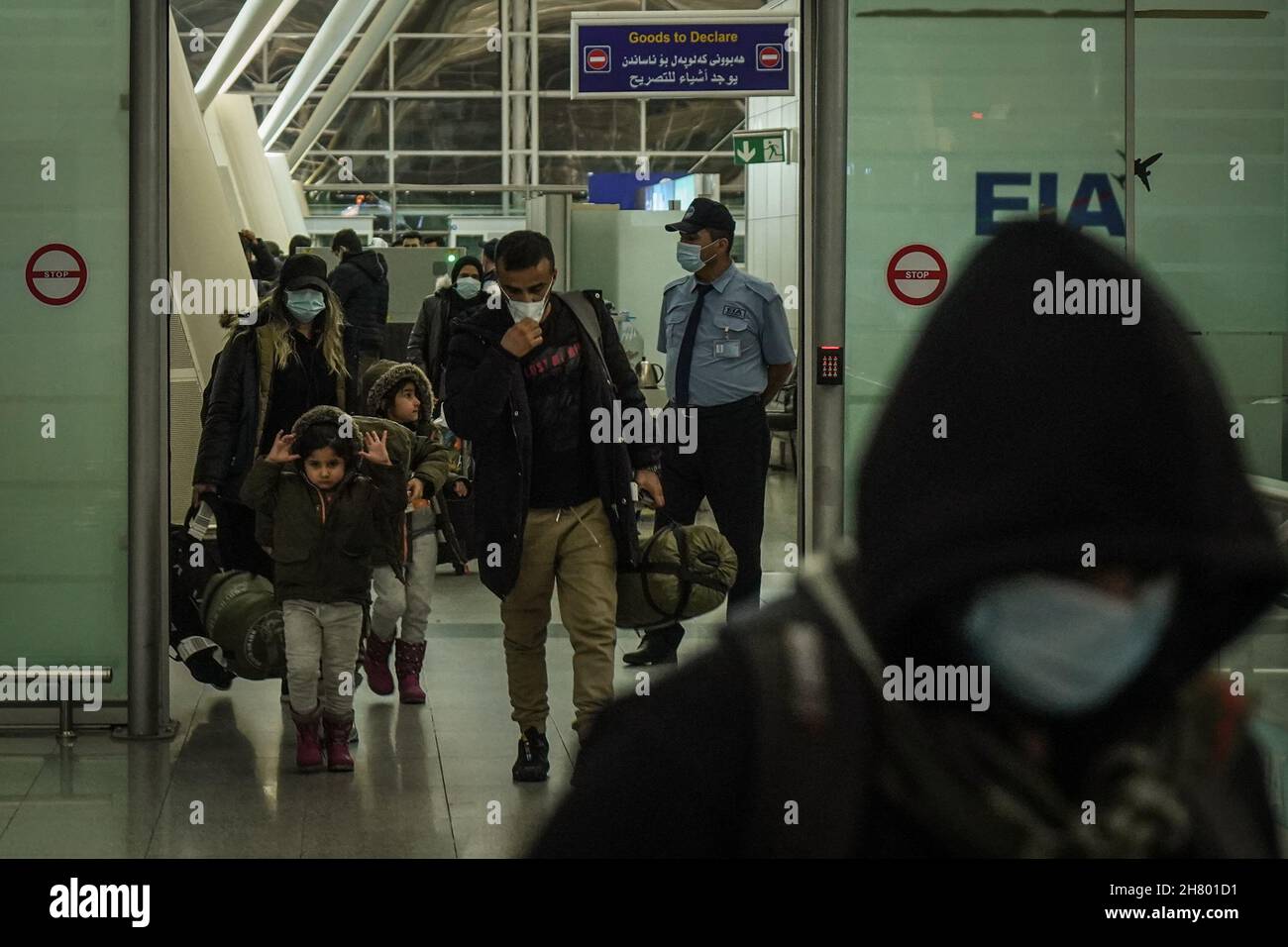 Erbil, Iraq. 26th Nov, 2021. Iraqi migrants, who were stranded for weeks along the Polish-Belarusian borders, walk through the arrivals terminal at Erbil International Airport, after arriving on board a repatriation flight sent by the Iraqi government. Credit: Ismael Adnan/dpa/Alamy Live News Stock Photo
