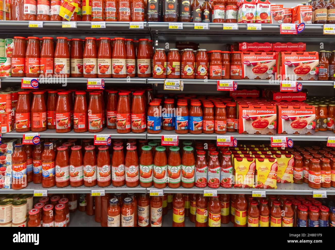 Fossano, Italy - November 25, 2021: glass jars of peeled tomato puree displayed on italian supermarket shelf Stock Photo