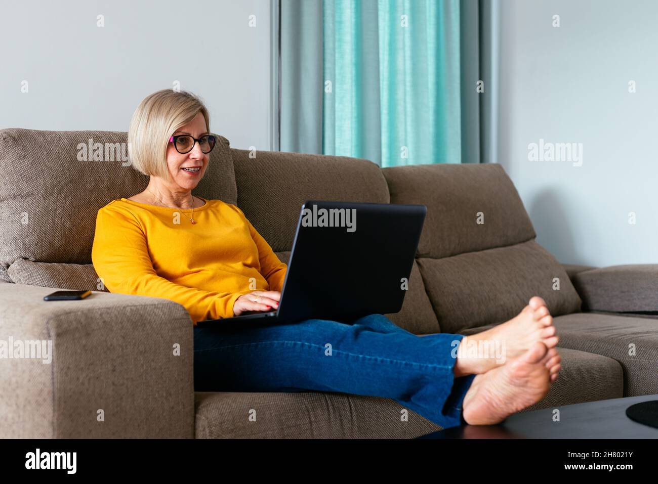 Mature female barefoot in jeans hi-res stock photography and images - Alamy