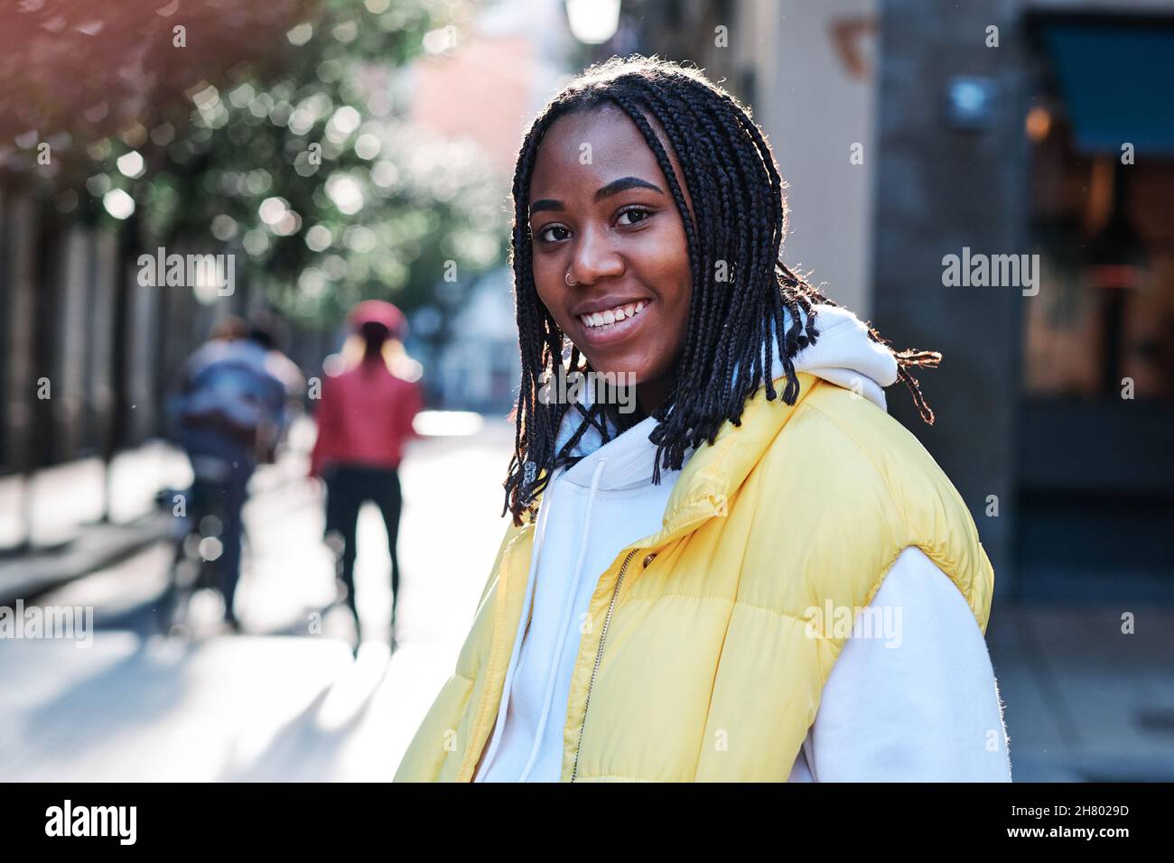 Young woman smiling while standing outdoors. Stock Photo