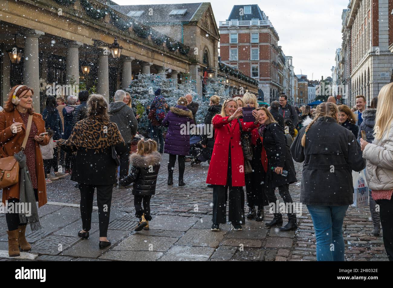 People react happily to being showered with artificial snow, part of a
