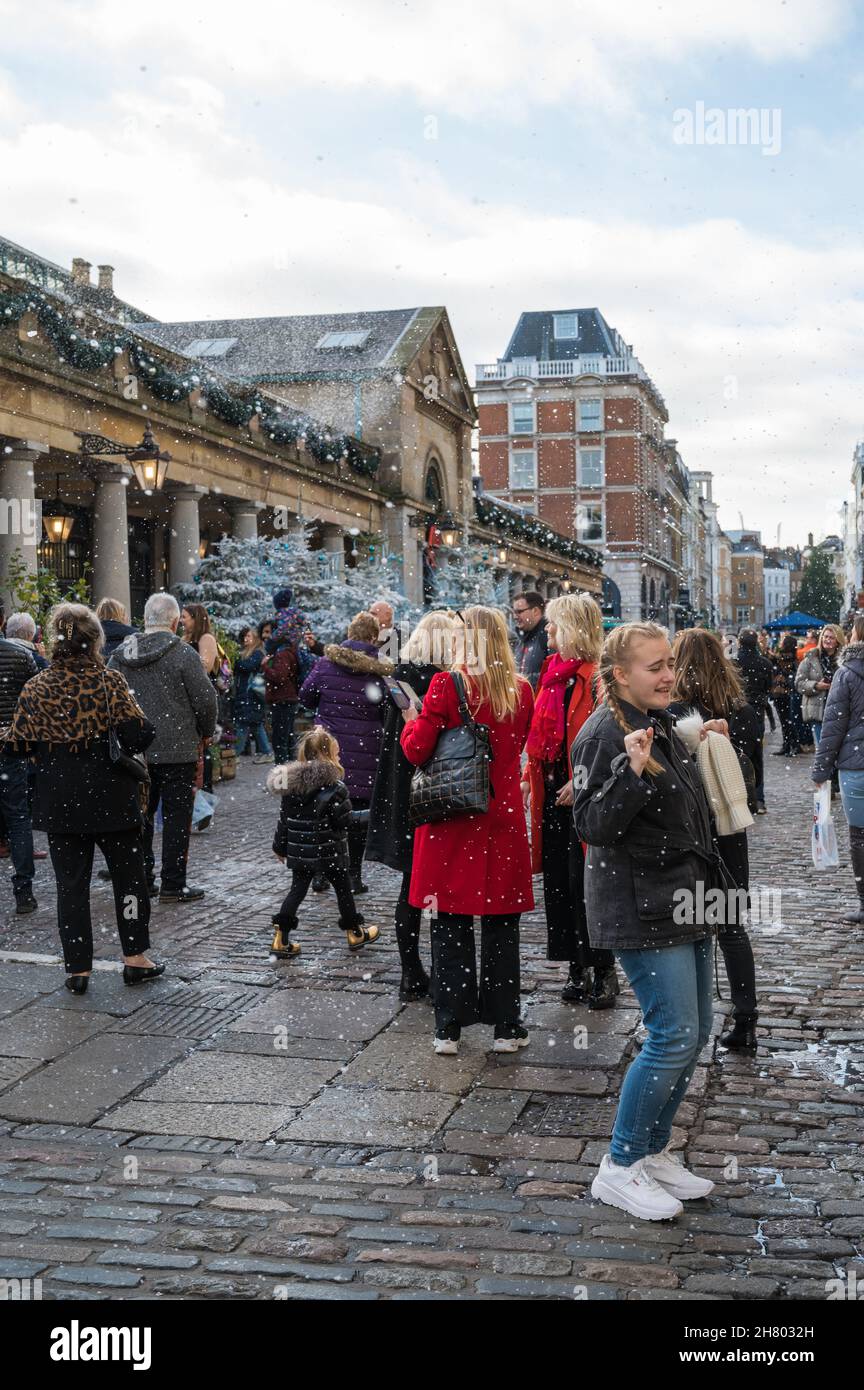 People react happily to being showered with artificial snow, part of a