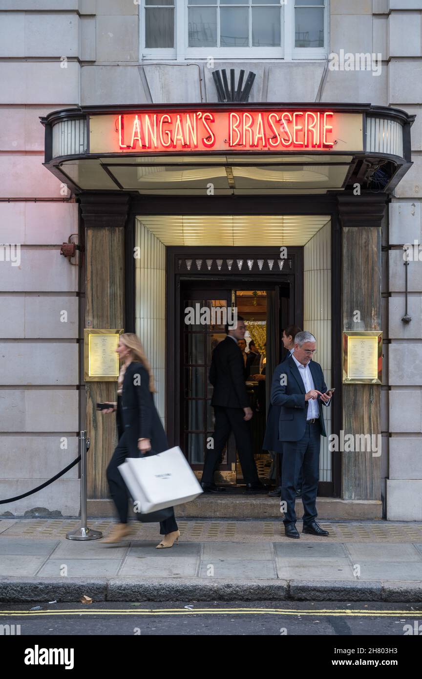 People at the main entrance to Langan's Brasserie. Stratton Street, Mayfair, London, England, UK Stock Photo