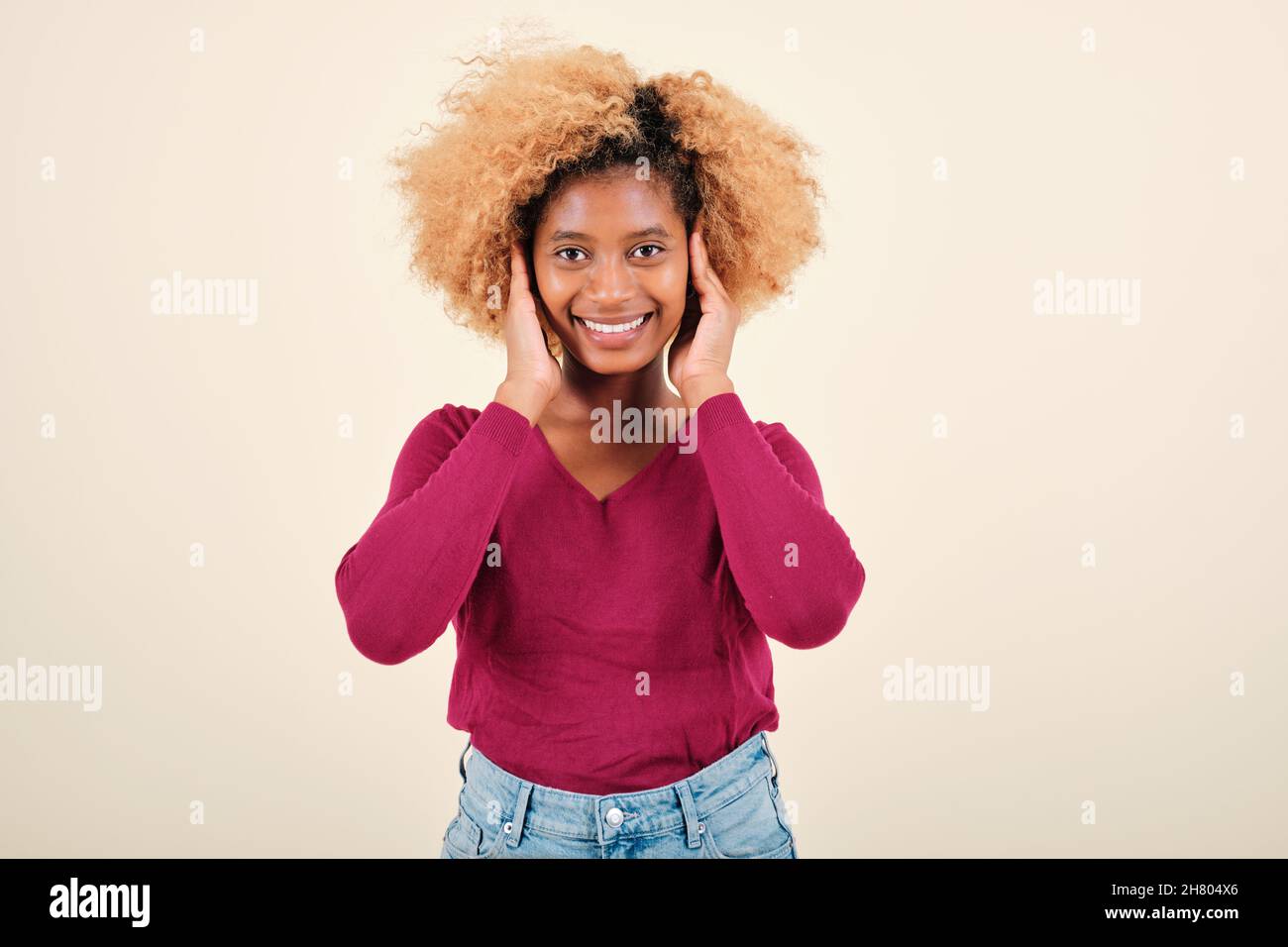 Young curly-haired woman smiling while standing over an isolated background. Stock Photo