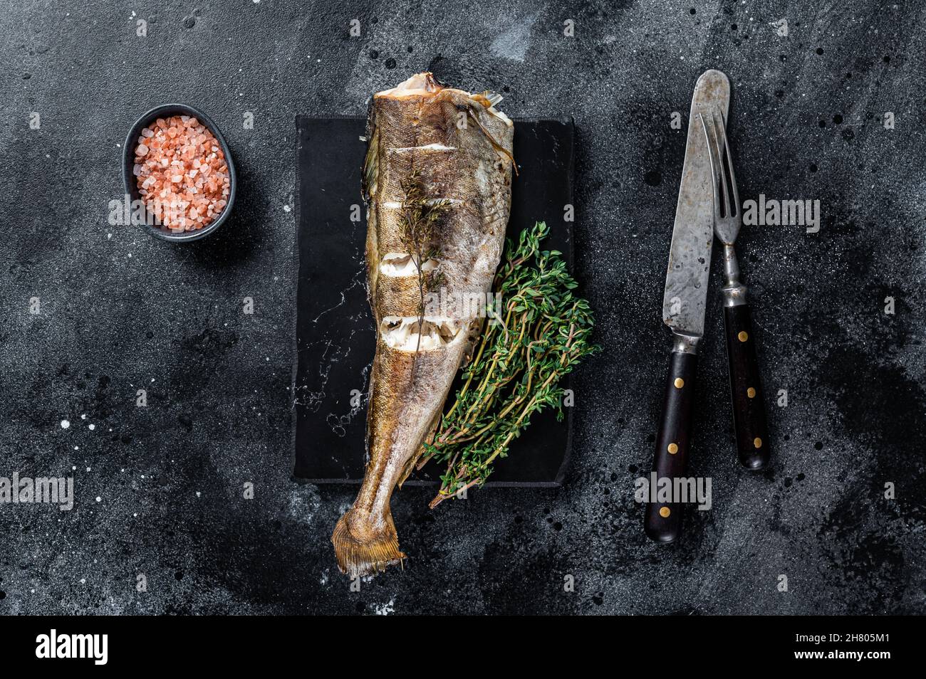 Marbled Cod Roasted cod white fish with thyme on marble board. Black background ...