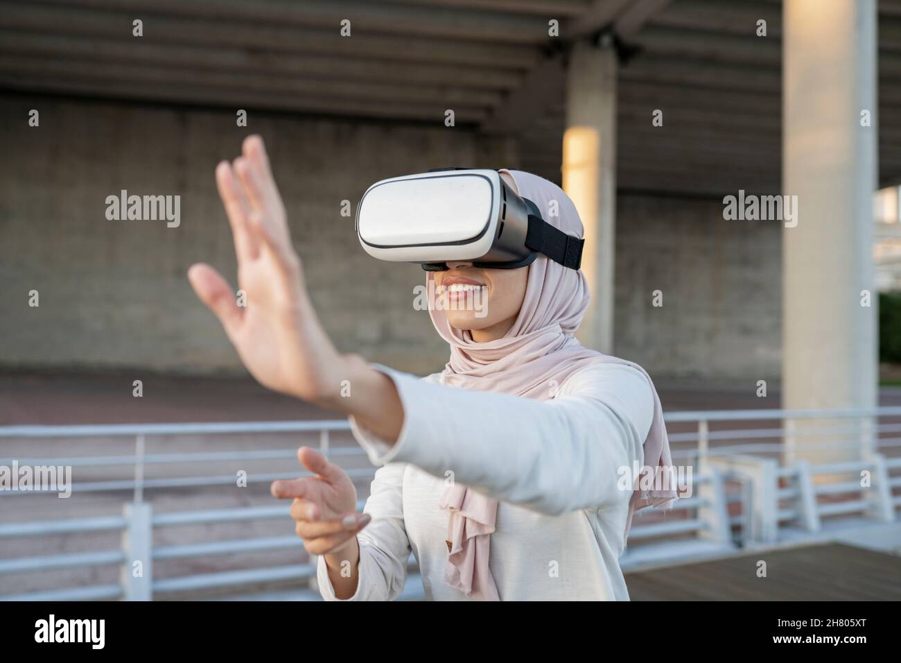 Side View Of Positive Arab Female In Traditional Hijab And Modern Vr Goggles While Experiencing