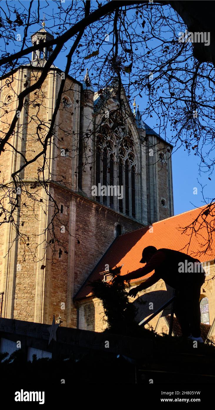 Brunswick, Germany. 22nd Nov, 2021. A man works below the cathedral to decorate a stall at the Braunschweig Christmas market. Despite rising numbers of Covid 9 sufferers in the population, Christmas markets are taking place in Lower Saxony. Credit: Stefan Jaitner/dpa/Alamy Live News Stock Photo