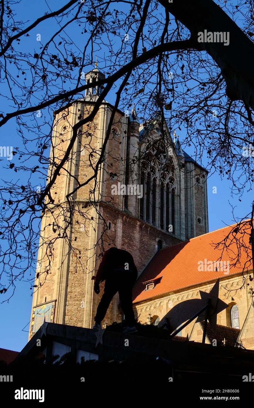 Brunswick, Germany. 22nd Nov, 2021. A man works below the cathedral to decorate a stall at the Braunschweig Christmas market. Despite rising numbers of Covid 9 sufferers in the population, Christmas markets are taking place in Lower Saxony. Credit: Stefan Jaitner/dpa/Alamy Live News Stock Photo