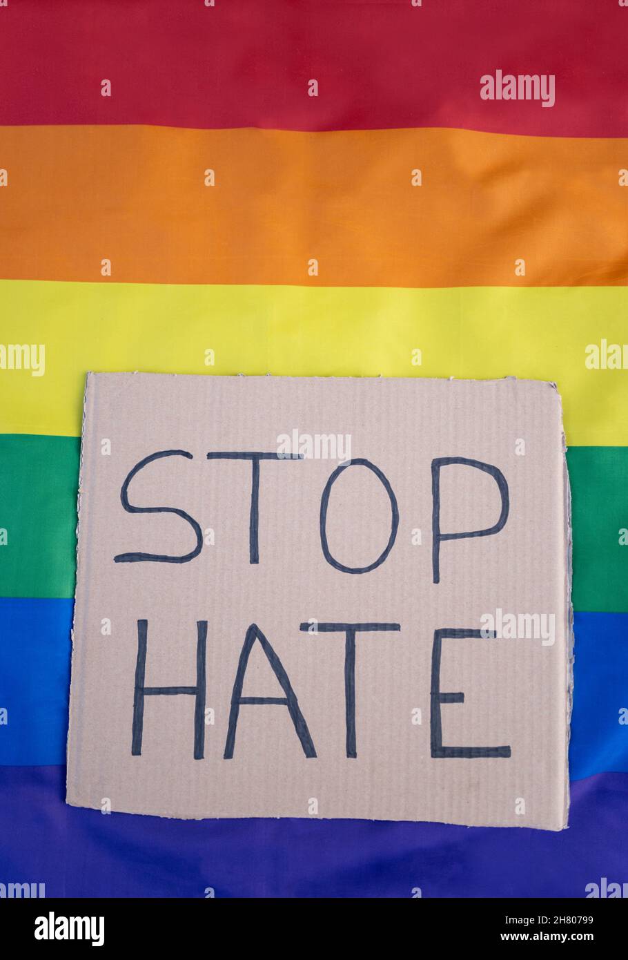 Top view full body carton with Stop Hate inscription placed on colorful  rainbow LGBT flag on light street in city Stock Photo - Alamy