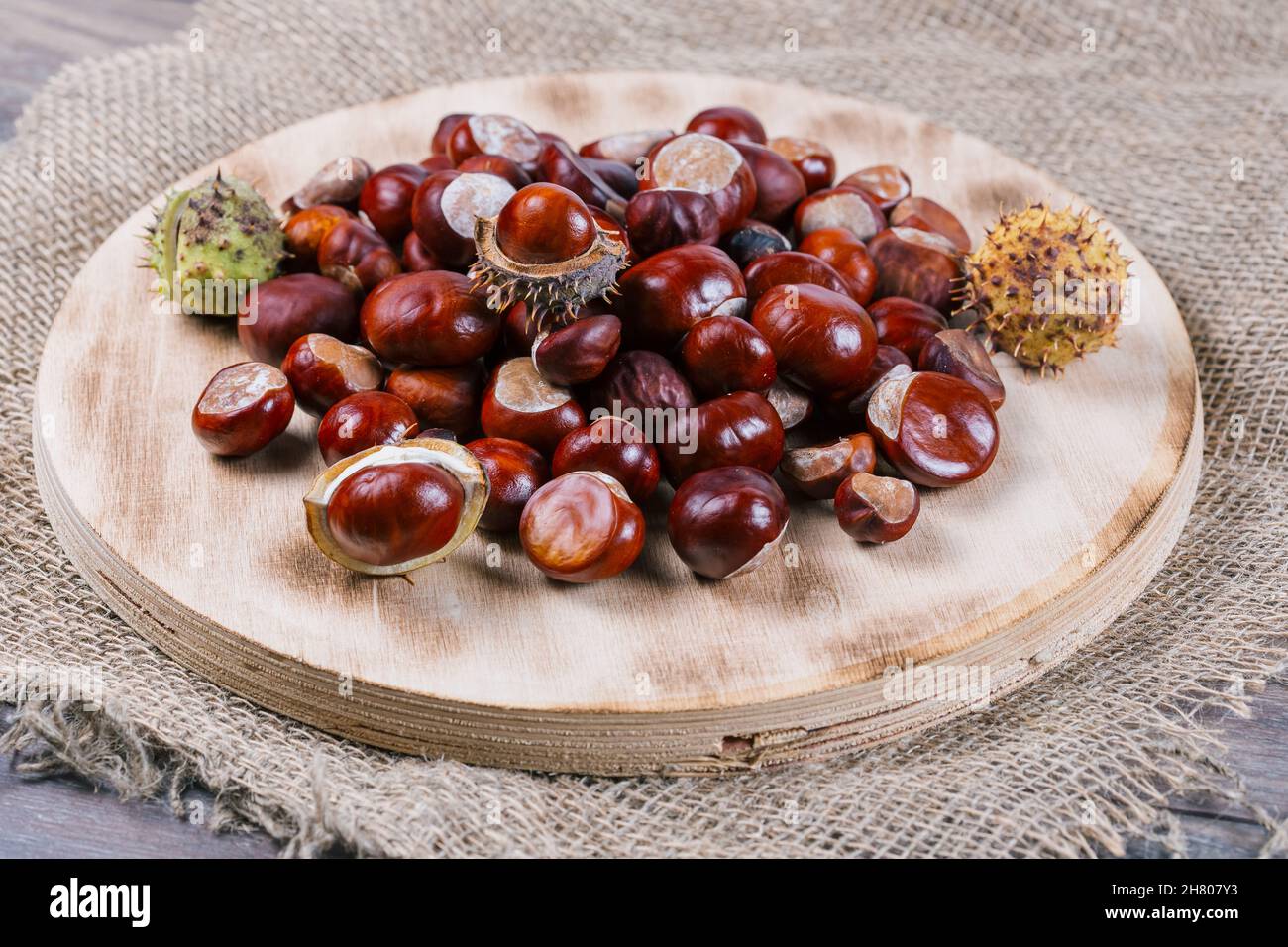 Edible chestnut kernels lie on a wooden cutting board made of plywood. Stock Photo