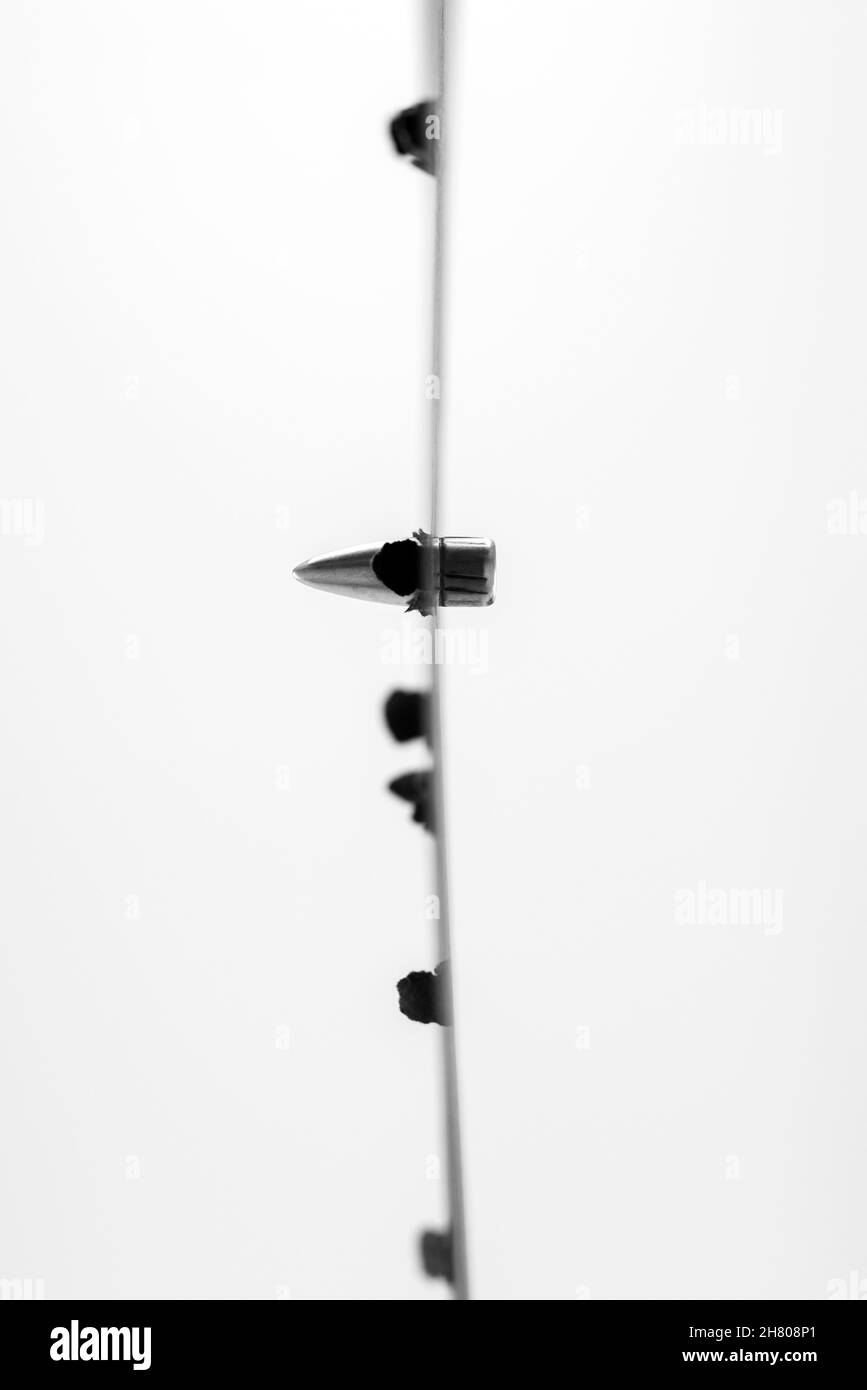 A bullet passing through an obstacle on white background Stock Photo