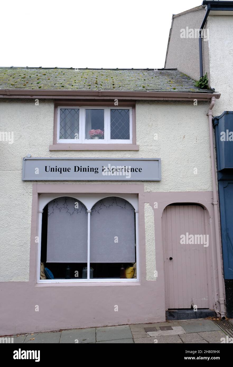 An exterior view of a Welsh seaside restaurant with the sign advertising an amusing and questionable unique dining experience. Stock Photo