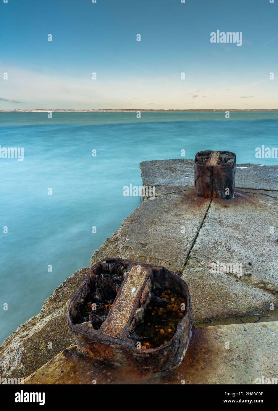 rusty mooring bollards on old derelict concrete seaside pier on the isle of wight coastline, isle of wight seashore, corroded old nautical fittings. Stock Photo