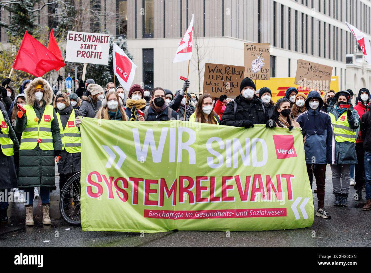 Munich, Germany. 26th Nov, 2021. Demonstration participants hold a banner with the inscription 'Wir sind systemrelevant - Beschäftigte im Gesundheits- und Sozialwesen' in front of them during a demonstration of hospital employees in front of the inner city hospital. In the run-up to the 3rd round of negotiations in the public service of the Länder on 27 and 28 November 2021 in Potsdam, according to Verdi, the employees of the university hospitals in Augsburg, Regensburg, Munich, Erlangen and Würzburg want to participate in work stoppages. Credit: Matthias Balk/dpa/Alamy Live News Stock Photo