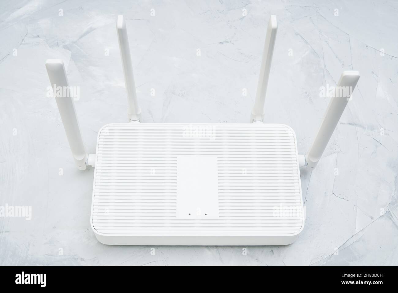 Top view of a dual band wi-fi 6 router with four antennas placed on a concrete table Stock Photo