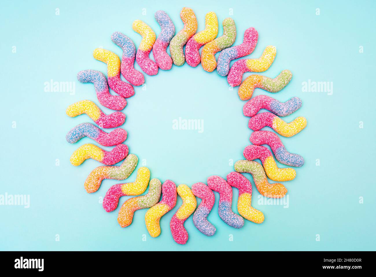 Sun made of z-shaped sugar coated gummy worms isolated on blue background Stock Photo