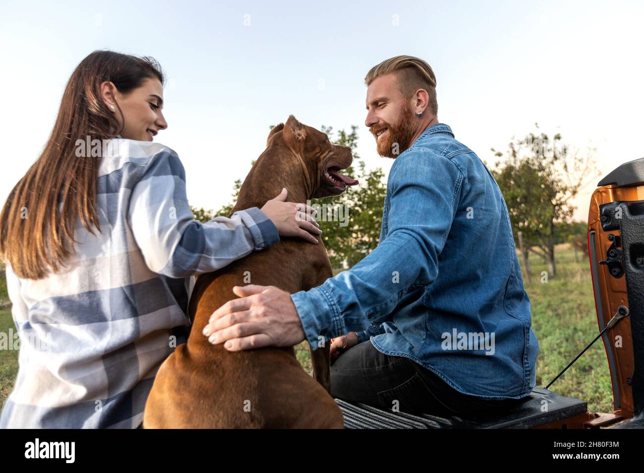 Cute young couple with a dog Stock Photo - Alamy