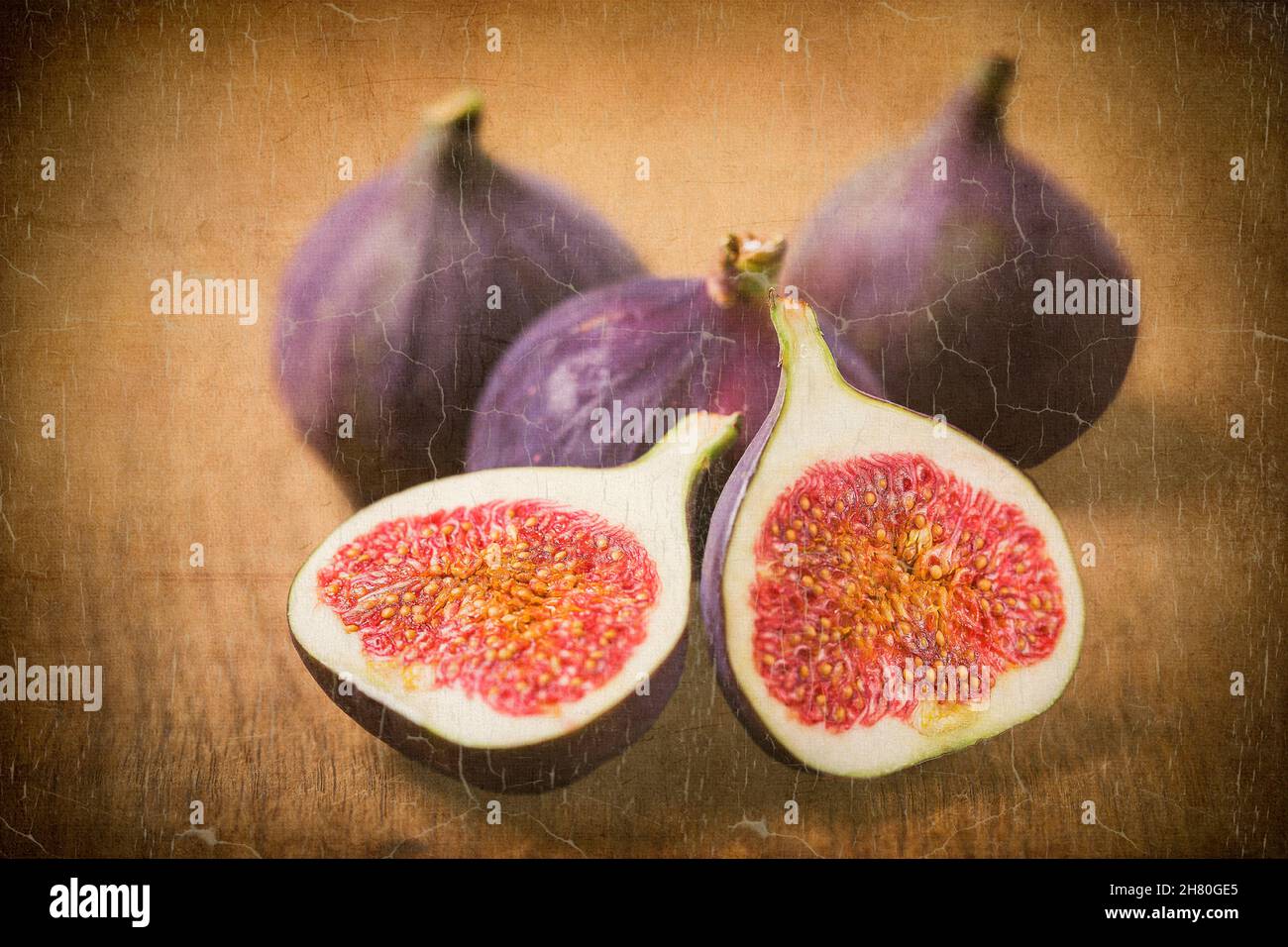 food still life, three figs and one sliced juicy fig in the foreground, textured for artistic effect and old painting effect Stock Photo