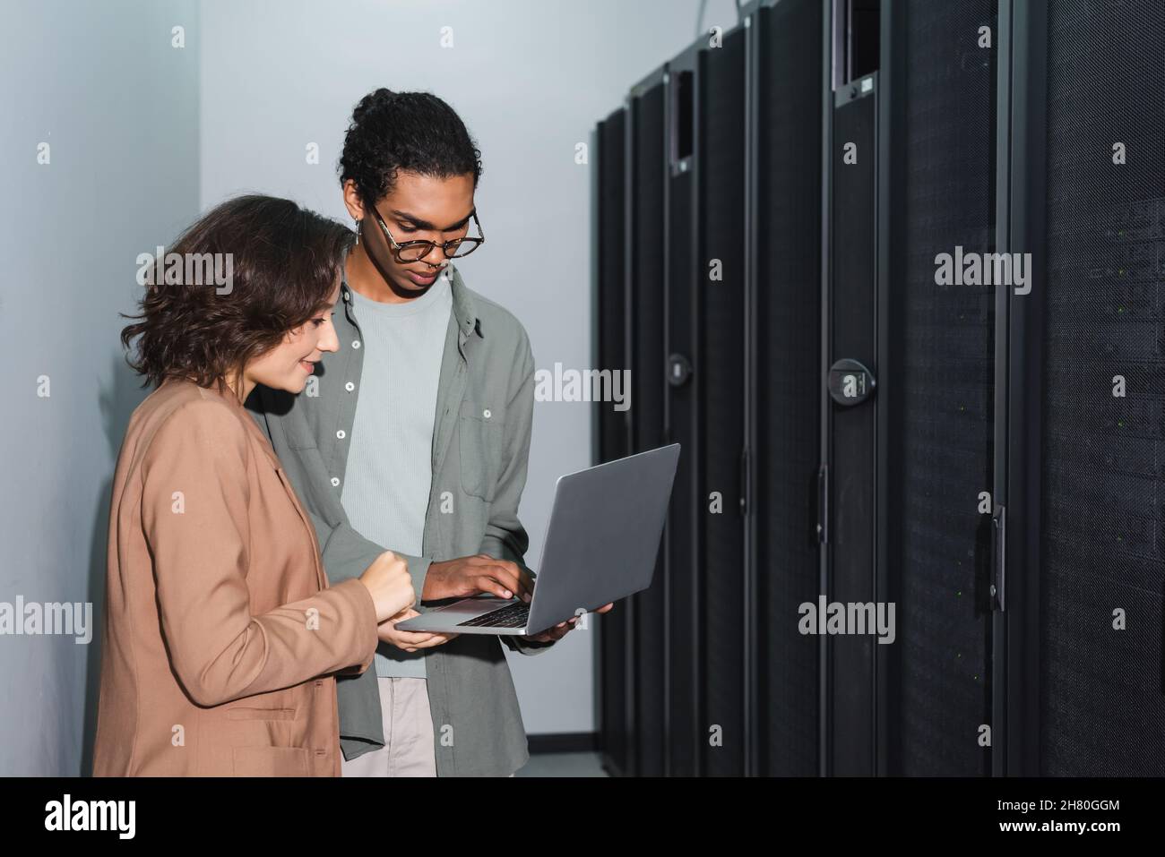 young interracial engineers using laptop while working in data center Stock Photo
