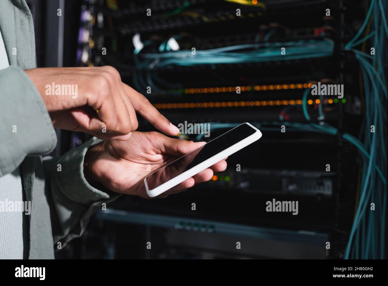 Smartphone Programmer cropped view of african american programmer pointing at smartphone with ...