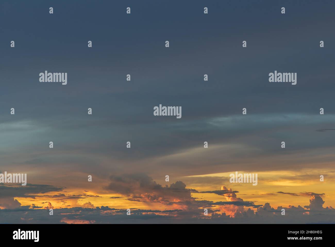 The sun shines through the clouds in the sunset sky with dramatic light ...