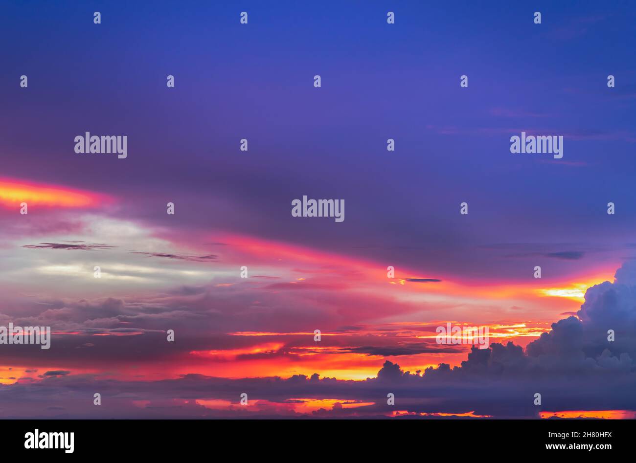 The sun shines through the clouds in the sunset sky with dramatic light ...