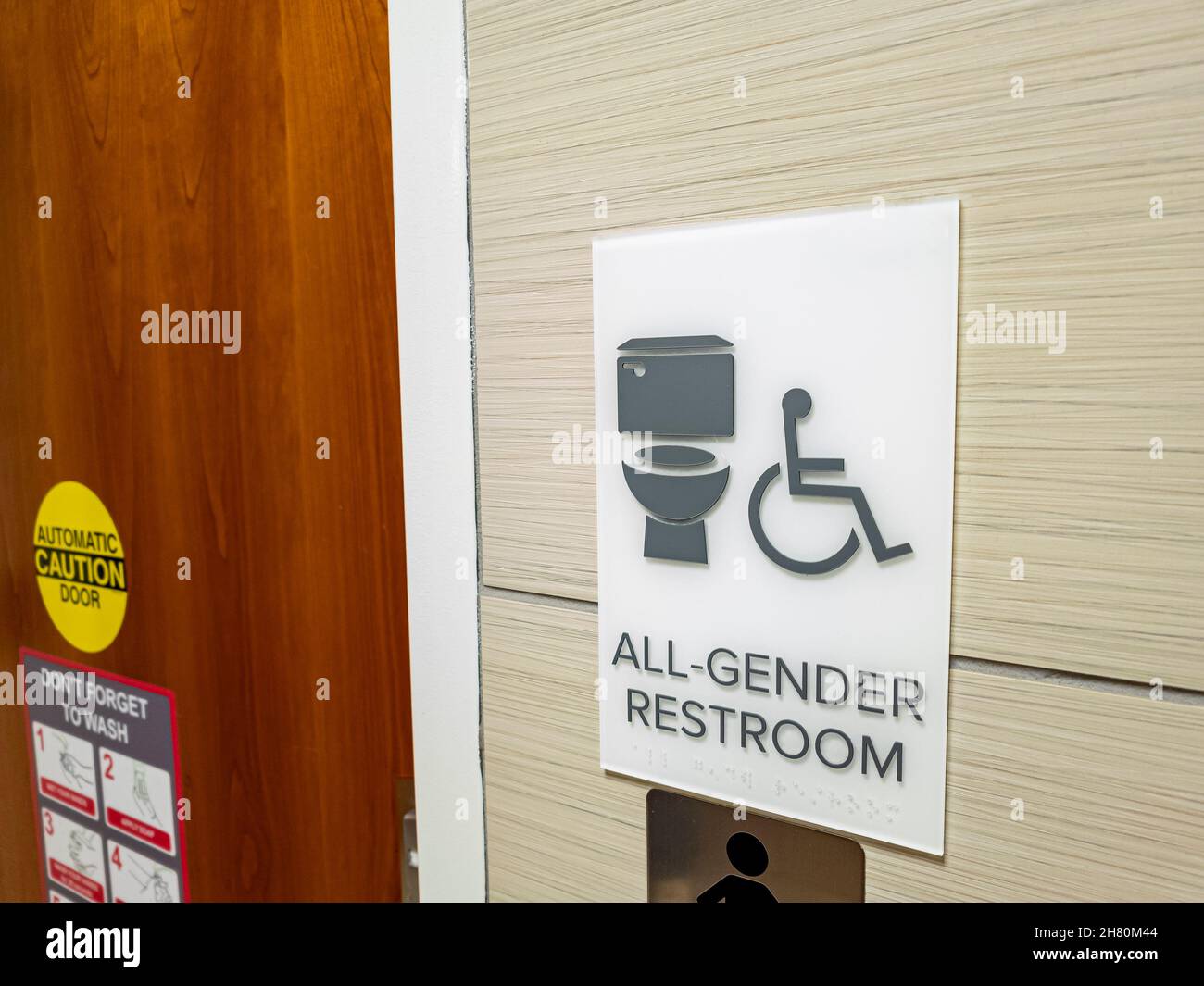 Close up isolated image showing all gender restroom sign at the entrance of a public toilet. These facilities are getting more common and popular acrr Stock Photo