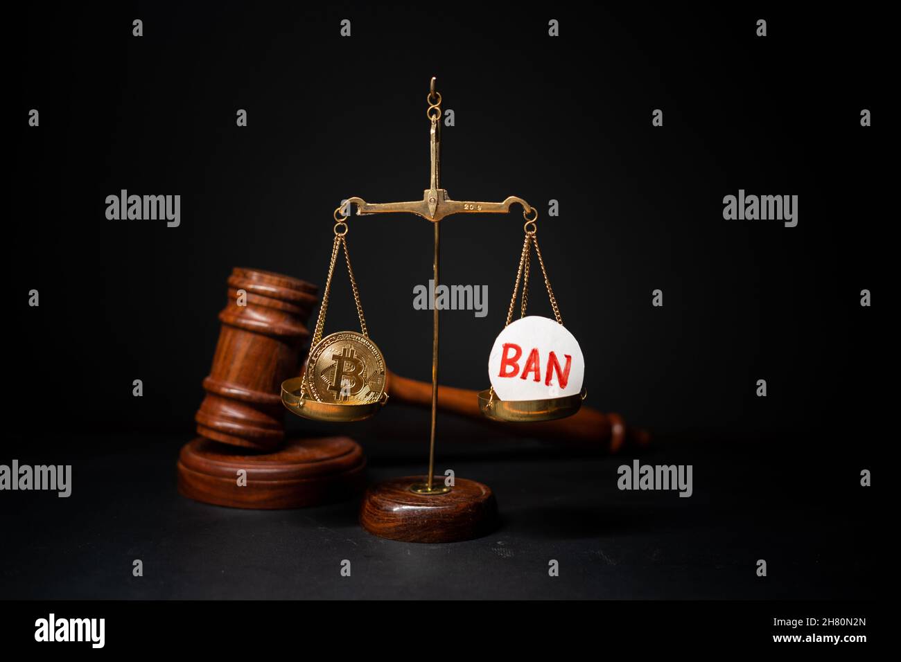 Maski, India - 26 November, 2021 : concpet of cryptocurrency ban showing with Bit coin and ban sybmol on balance scale with judge hammer on background Stock Photo