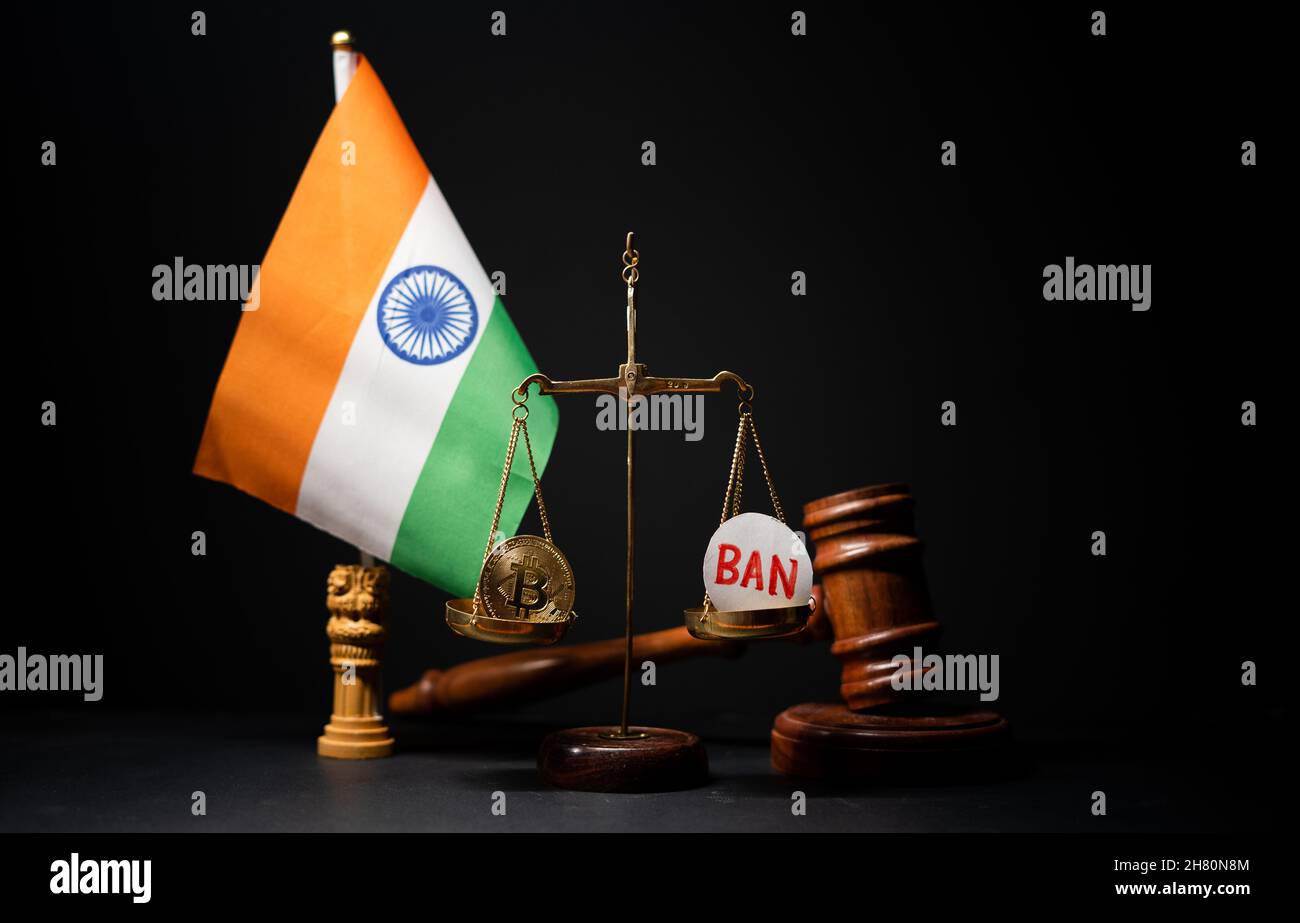 Maski, India - 26 November, 2021 : concpet of cryptocurrency ban in India, showing with Bit coin and ban sybmol on balance scale with judge hammer on Stock Photo