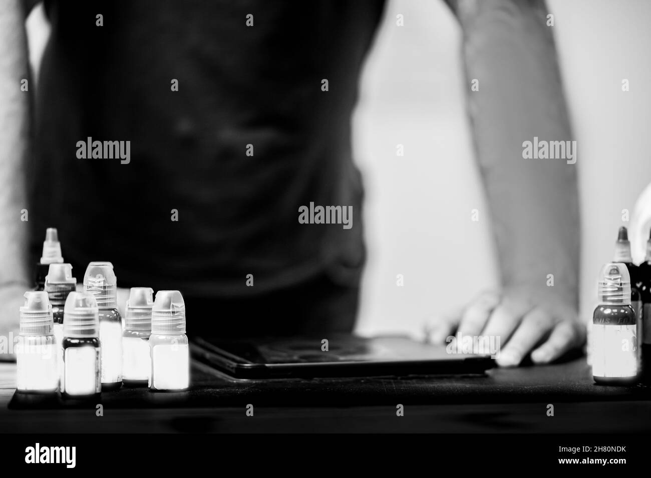 Workplace of tattoo artist with ink for drawings and graphic tablet for