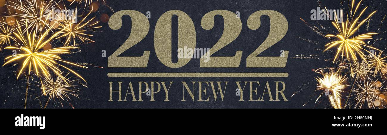 HAPPY NEW YEAR 2022 - Festive silvester New Year's Eve Party background panorama greeting card banner long - Golden fireworks in the dark black night Stock Photo