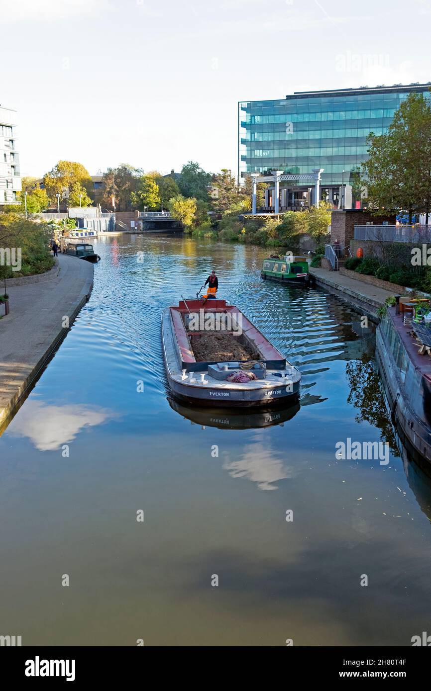 Man driving barge with load on the Regents Canal vertical view from the