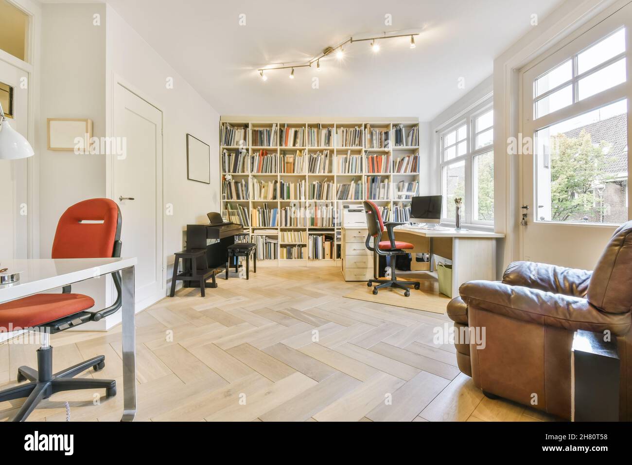 Large cozy living room with a large wall-to-wall library Stock Photo