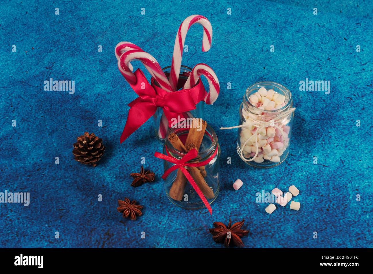 Top view of Christmas sweets. decorated glass jars with marshmallows on a blue surface Stock Photo