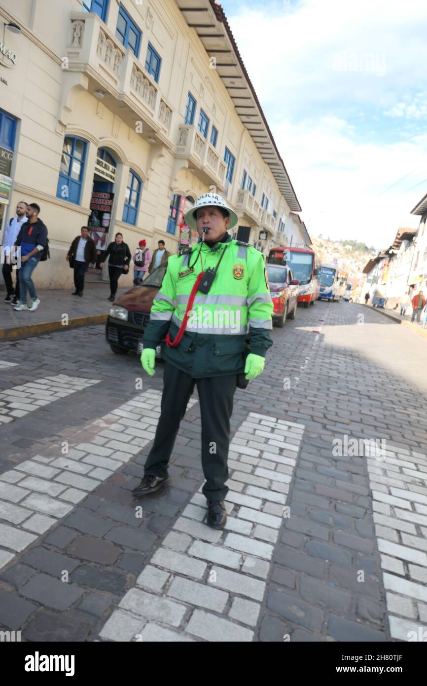 policeman in Cuzco Peru centre of town traffic cop with whistle blowing letting people  cross the road tourists tourist cross sun hat blower happy Stock Photo