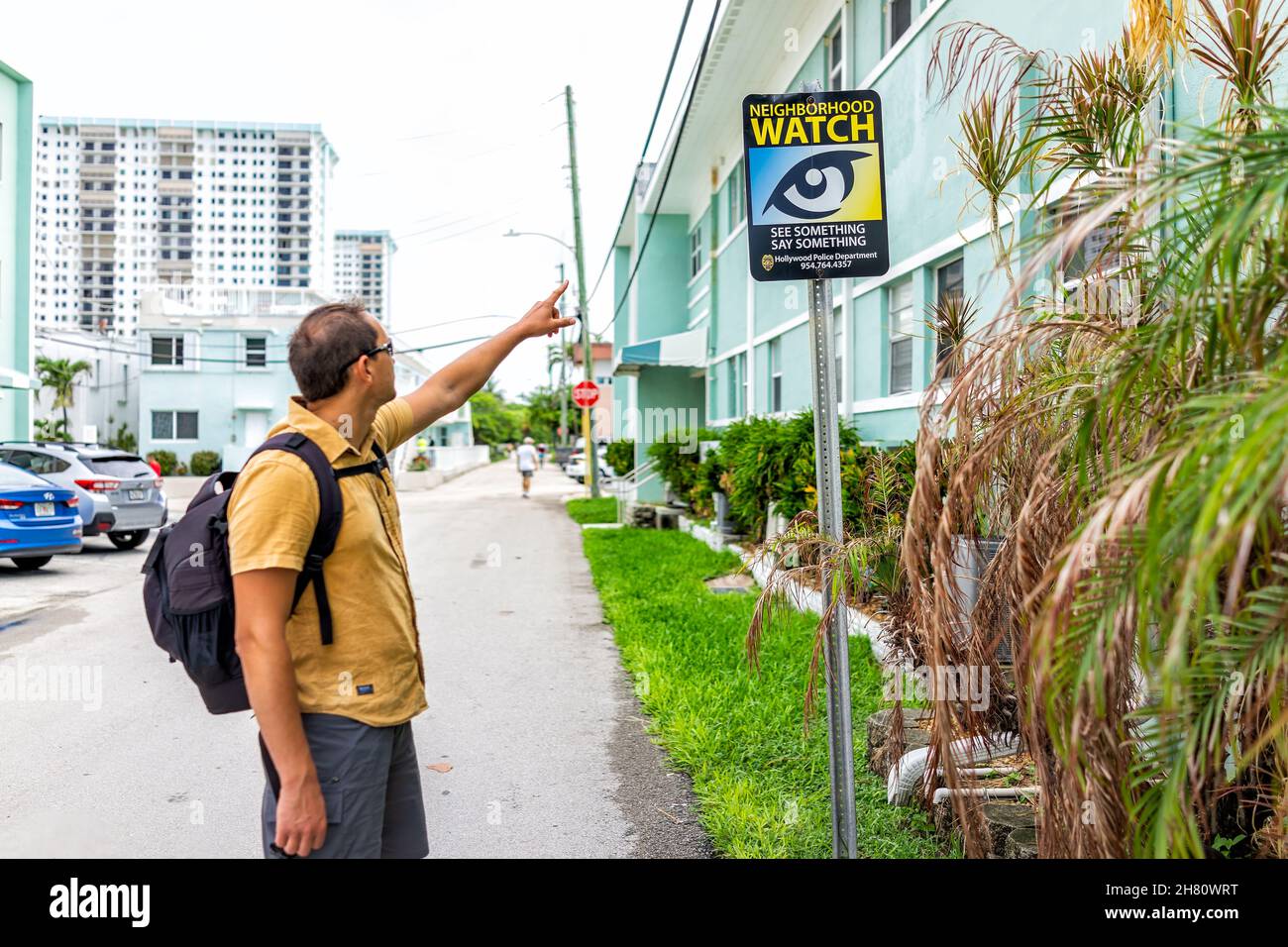 Hollywood, USA - August 4, 2021: North Miami, Hollywood beach, Florida residential district near broadwalk and beachfront building with man pointing a Stock Photo