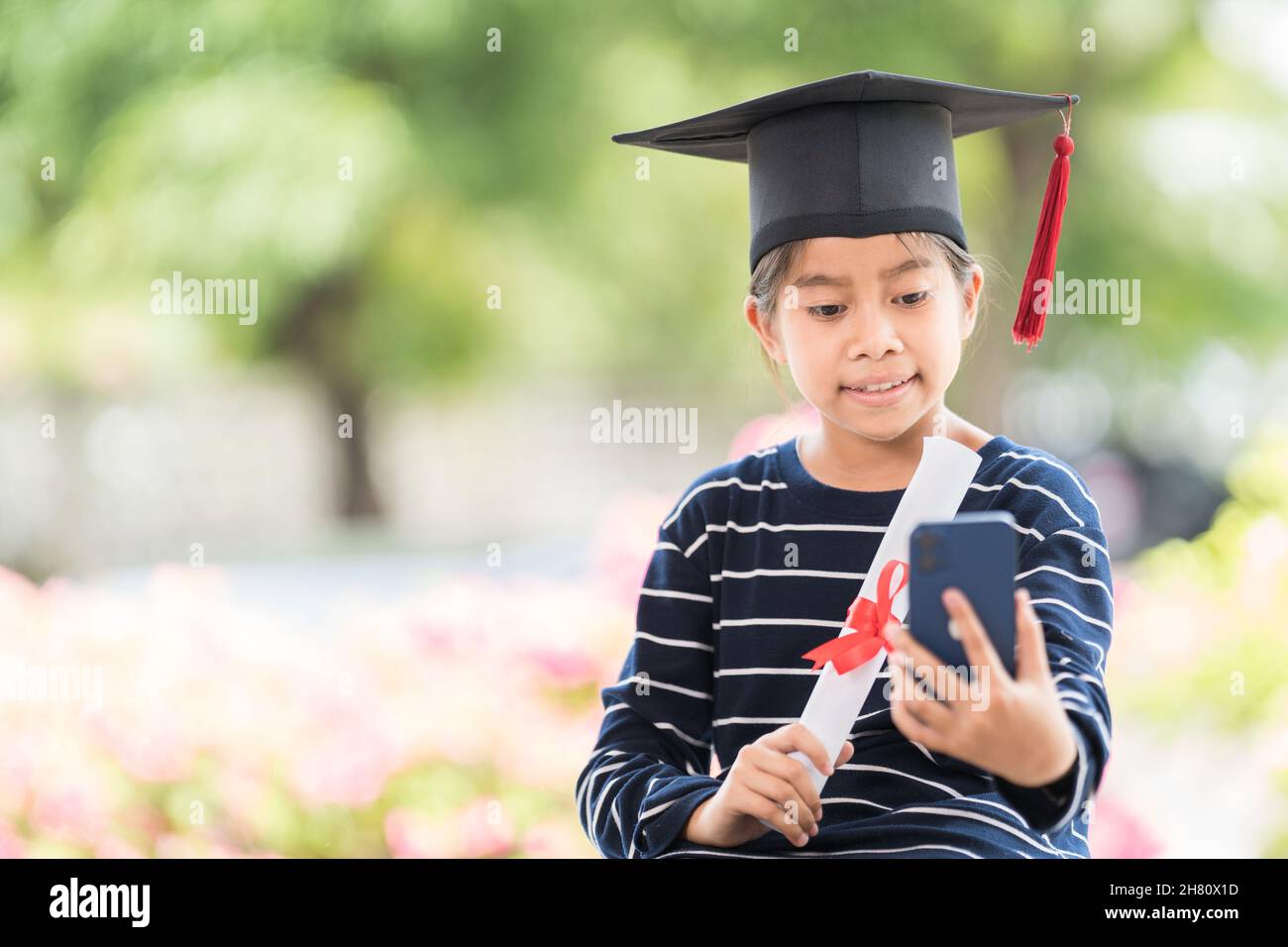 Happy Southeast Asian Schoolgirl With A Certificate And Smartphone During Graduation In Thailand 